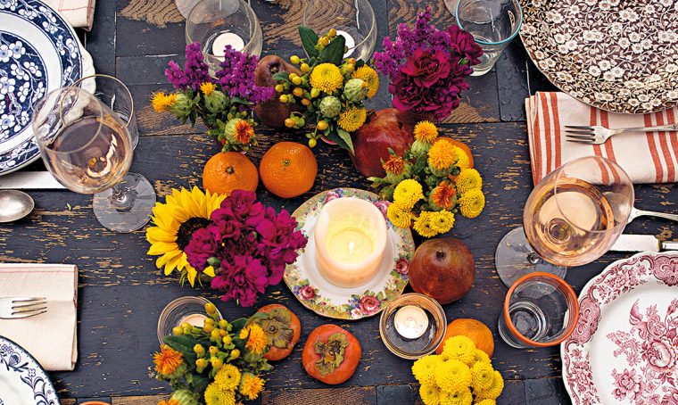 Il centrotavola autunnale con fiori, frutta e candele