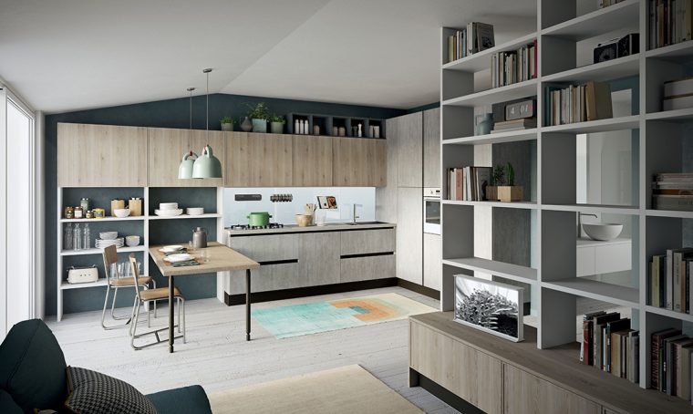 Nel monolocale la cucina a vista con scaffali e penisola