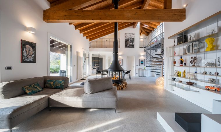 Un grande open space ristrutturato con arredi minimal e materiali naturali dalle tonalità calde
